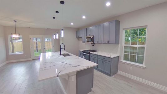 Welcome to 8127 Venus St bright open kitchen island. (Picture is of a finished home.)