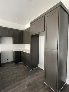 Kitchen featuring gray cabinets, decorative backsplash, and dark hardwood / wood-style floors