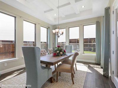 Dining area featuring a notable chandelier, beam ceiling, hardwood / wood-style flooring, and coffered ceiling