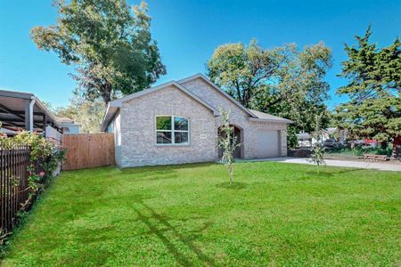 View of front of property featuring a front yard and a garage