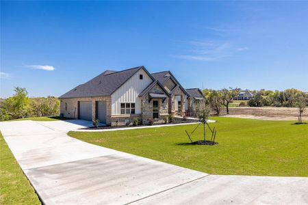 View of front of property with a garage and a front lawn