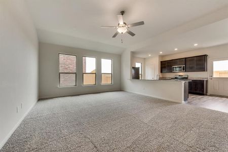 Unfurnished living room featuring light wood-type flooring, sink, and ceiling fan