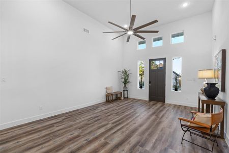 Entryway featuring a towering ceiling, ceiling fan, and dark hardwood / wood-style floors