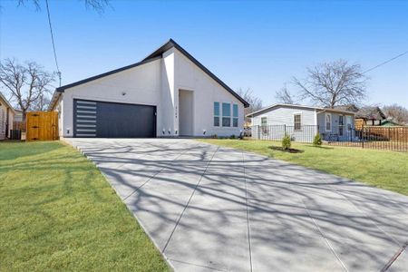 Mid-century inspired home featuring cooling unit, concrete driveway, fence, and a front lawn