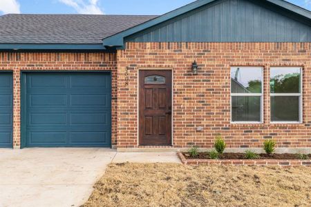 View of exterior entry with a garage