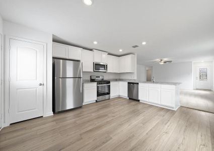 Upgraded kitchen with granite countertops and white cabinetry.