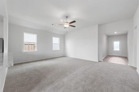 Living room featuring light colored carpet and ceiling fan