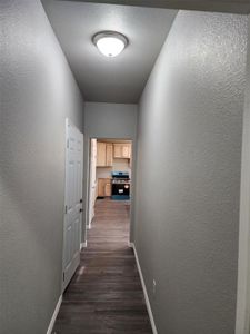 Corridor with dark hardwood / wood-style flooring