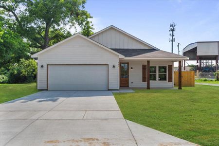 View of front of property featuring a garage and a front yard