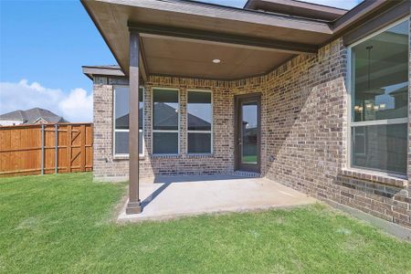 Entrance to property with a patio area and a lawn