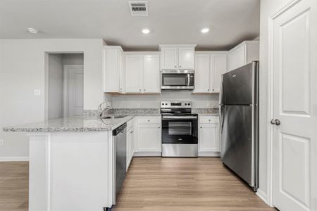 The kitchen is fully equipped with Whirlpool kitchen appliances and granite countertops.