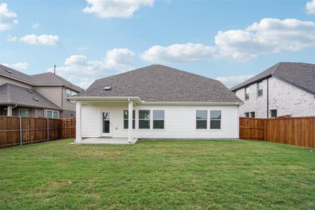 Rear view of house featuring a patio and a lawn