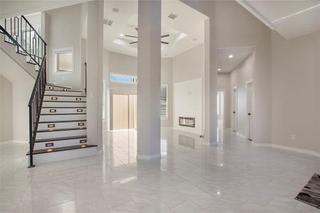 Stairs with a towering ceiling and ceiling fan