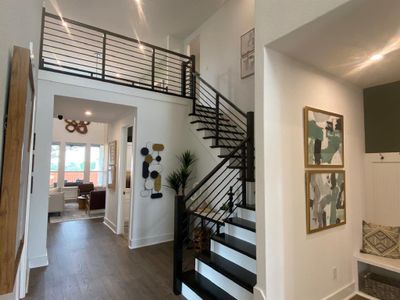 Solid wood stairs with horizontal railing lead up to the second story catwalk