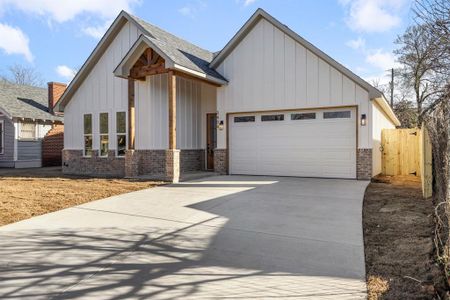 Modern inspired farmhouse with a garage, a shingled roof, concrete driveway, board and batten siding, and brick siding