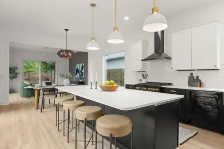 Kitchen featuring dishwasher, light countertops, wall chimney range hood, and backsplash