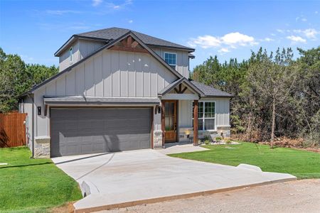 View of front of property featuring a front lawn and a garage