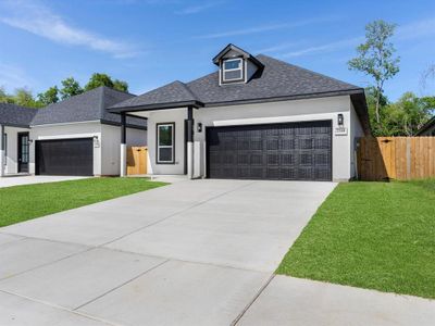 View of front of property with a front yard and a garage