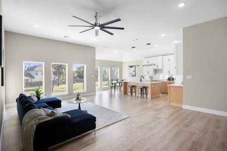 Living room with ceiling fan, sink, and light wood-type flooring