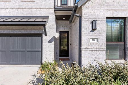 Built by Stonefield Homes in 2023, this residence features a stately brick exterior, an elegant front door, and a spacious attached two-car garage.