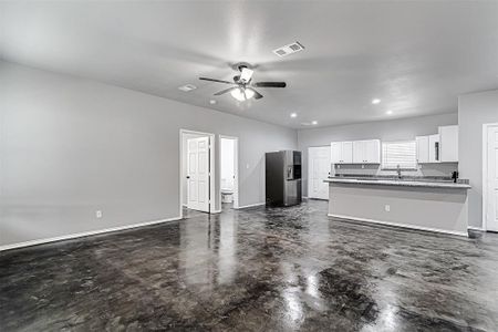 Kitchen with ceiling fan, stainless steel refrigerator with ice dispenser, white cabinets, sink, and kitchen peninsula