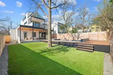 Back of property with stucco siding, a ceiling fan, a fenced backyard, a yard, and a fenced in pool