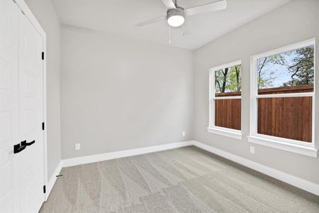 Unfurnished room with light colored carpet and ceiling fan