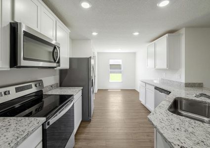 A beautiful white kitchen with a breakfast area.