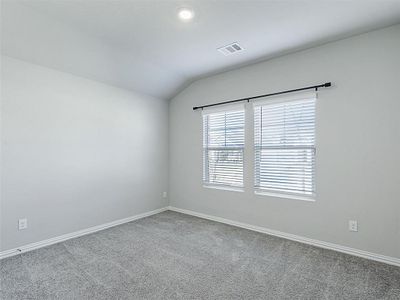 Empty room with carpet and vaulted ceiling