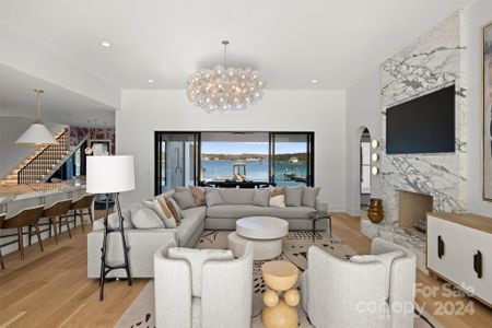 Living room with contemporary fireplace. Wood floors. Elegant lighting & finishes.