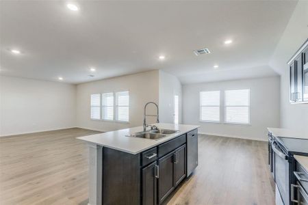 Kitchen featuring sink, light hardwood / wood-style flooring, plenty of natural light, a center island with sink, and appliances with stainless steel finishes