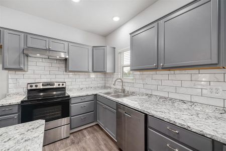 Kitchen featuring sink, stainless steel appliances, gray cabinets, and wood-type flooring