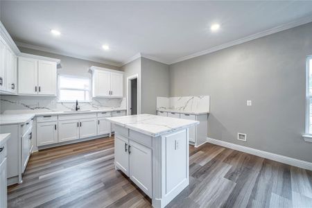 Kitchen featuring sink, a center island, white cabinetry, and dark hardwood / wood-style floors