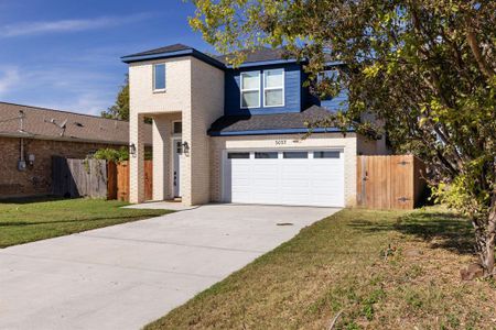 View of front of property featuring a garage and a front yard