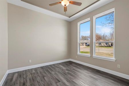 Empty room with ceiling fan and dark wood-type flooring