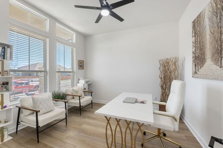 Home office with baseboards, light wood-style flooring, and a ceiling fan