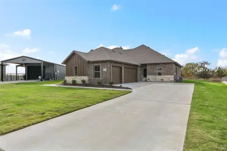 View of front of home with a front yard, a garage, and central air condition unit