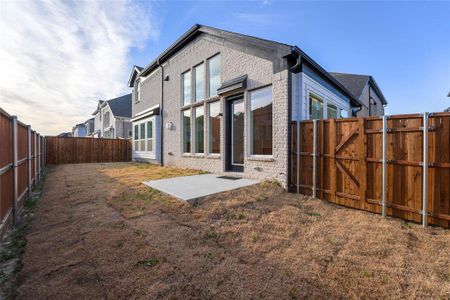 Rear view of house with a fenced backyard, a gate, a patio, and brick siding