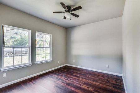 Unfurnished room featuring ceiling fan and dark hardwood / wood-style floors