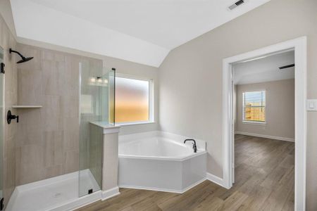 Welcome to the en-suite bathroom, featuring a chic vanity with ample storage space and a separate tub and shower combo for added luxury. Whether indulging in a soothing bath or refreshing shower, this well-appointed space offers the perfect retreat after a long day.