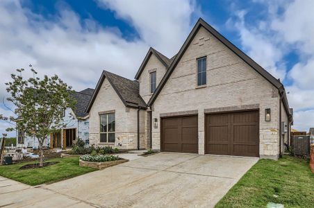 French country home with a garage and a front lawn