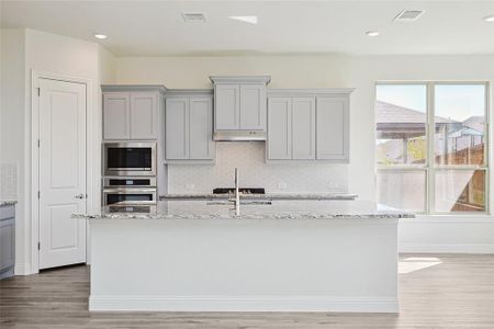 Kitchen featuring decorative backsplash, light hardwood / wood-style flooring, appliances with stainless steel finishes, and gray cabinetry