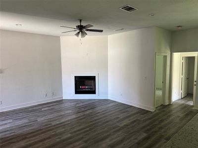 Living room with ceiling fan and dark hardwood / wood-style floors