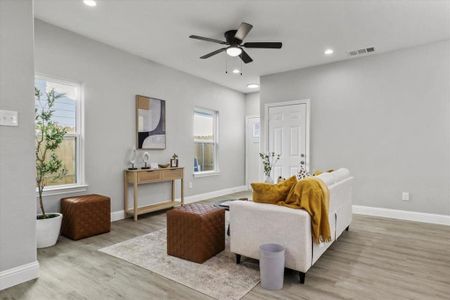 Living room featuring light hardwood / wood-style floors, a wealth of natural light, and ceiling fan