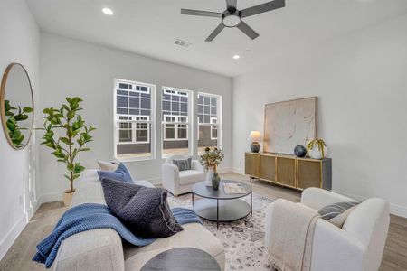 Living room with ceiling fan and light hardwood / wood-style floors