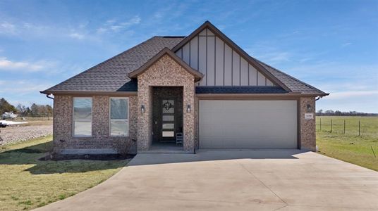 View of front facade with roof with shingles, concrete driveway, an attached garage, board and batten siding, and a front yard