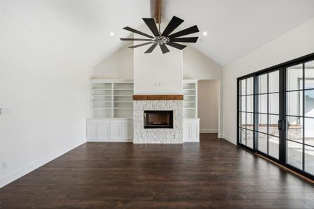 Unfurnished living room featuring high vaulted ceiling, ceiling fan, built in features, a fireplace, and dark hardwood / wood-style flooring