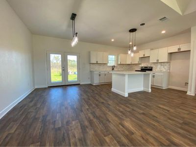 Kitchen featuring white cabinetry, plenty of natural light, and pendant lighting