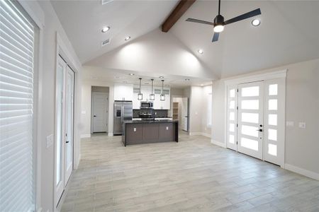 Kitchen with a center island with sink, hanging light fixtures, appliances with stainless steel finishes, and light hardwood / wood-style flooring