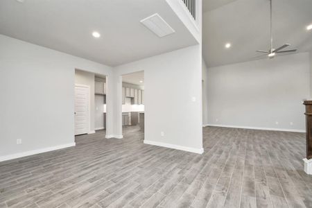 This roomy dining area boasts stylish flooring, personalized paint, and is conveniently situated next to the family room and kitchen, fostering an open and inclusive ambiance. Sample photo of completed home with similar floor plan. As-built interior colors and selections may vary.